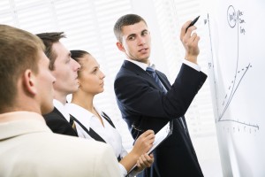 Businessman presenting his ideas on whiteboard to colleagues